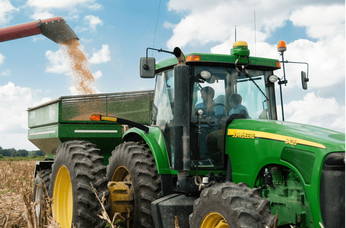 Trator descarregando grãos com foco em rastreabilidade e canal de denúncias no agro