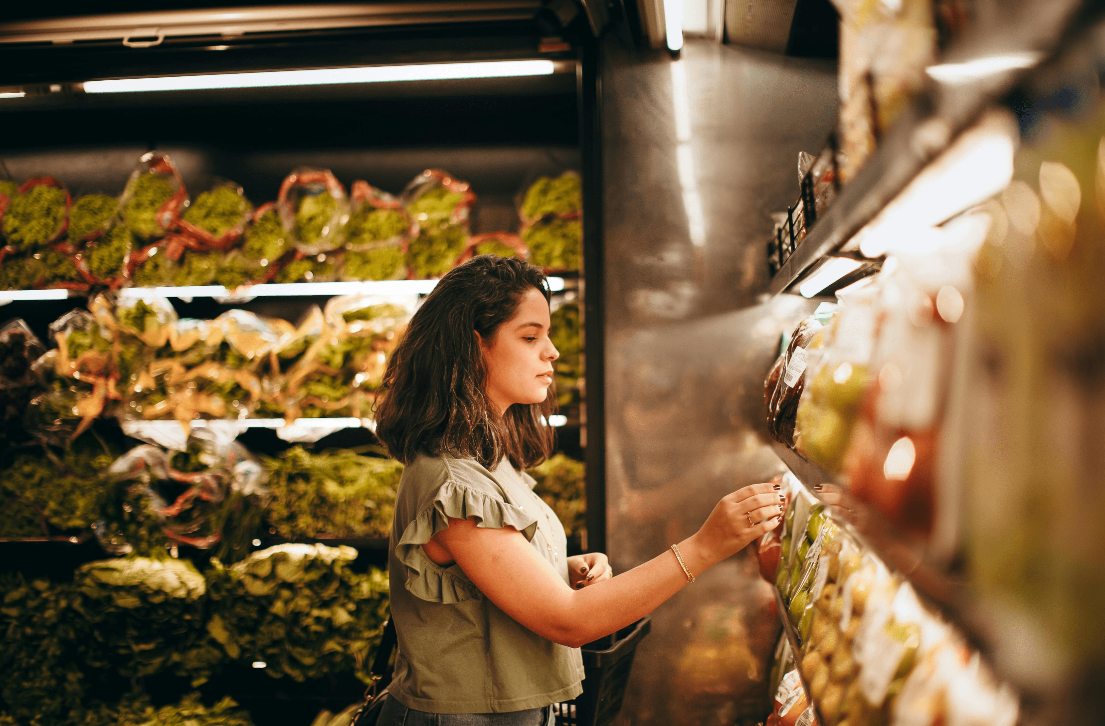 Jovem consumidora avaliando frutas frescas no supermercado .