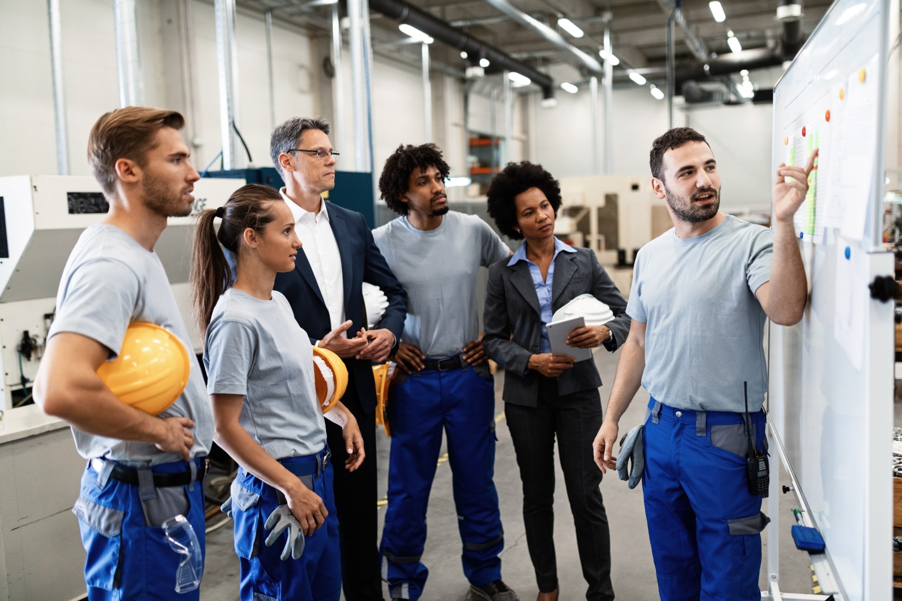 Funcionários utilizando equipamentos de proteção individual em ambiente industrial conforme normas de SST