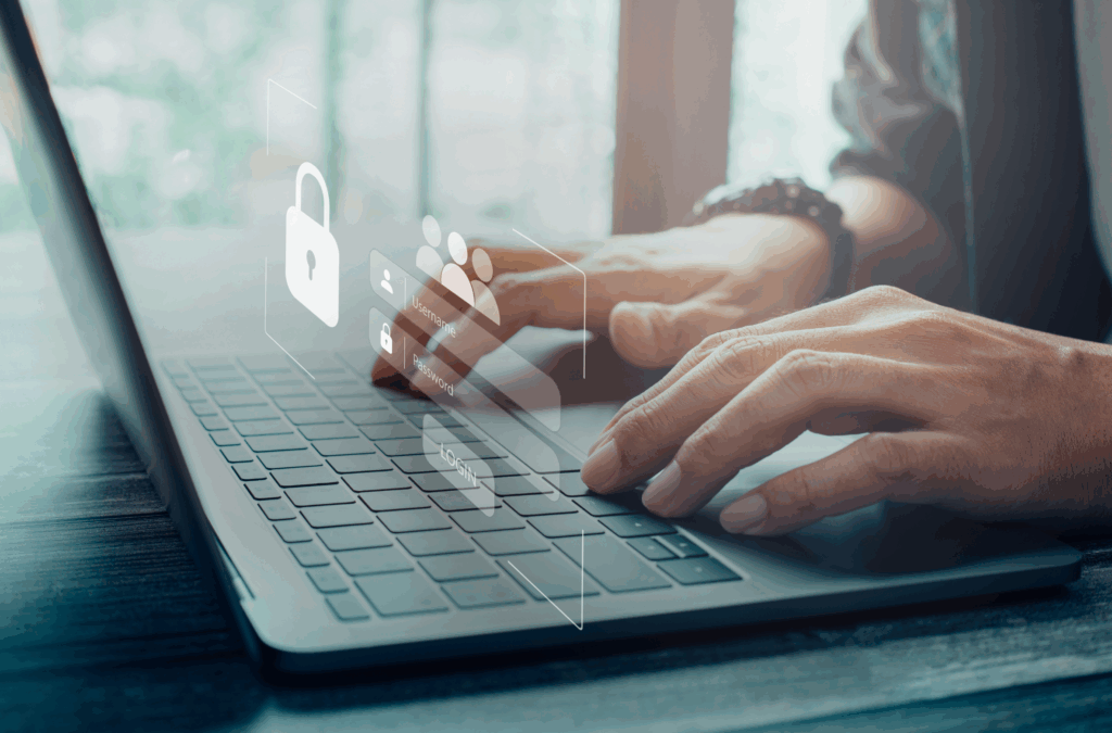 Mãos digitando em um laptop com ícones digitais de segurança projetados na tela, simbolizando práticas de LGPD para empresas.