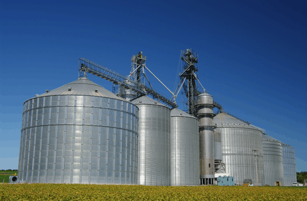 Silos metálicos de armazenamento de grãos em uma cooperativa agrícola, representando governança, transparência e a importância do canal de denúncias em cooperativas no setor agroindustrial.