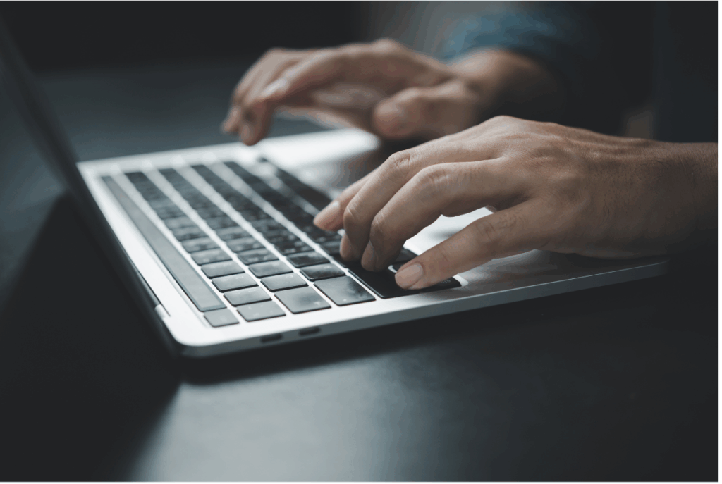 Pessoa digitando em notebook realizando registro de informações no sistema do Canal LGPD.