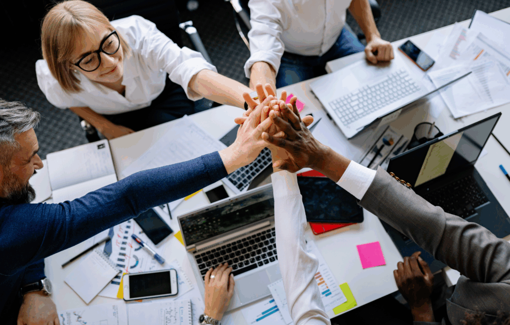 Equipe corporativa celebrando colaboração em iniciativas de compliance e ISO 37002 canal de denúncias.