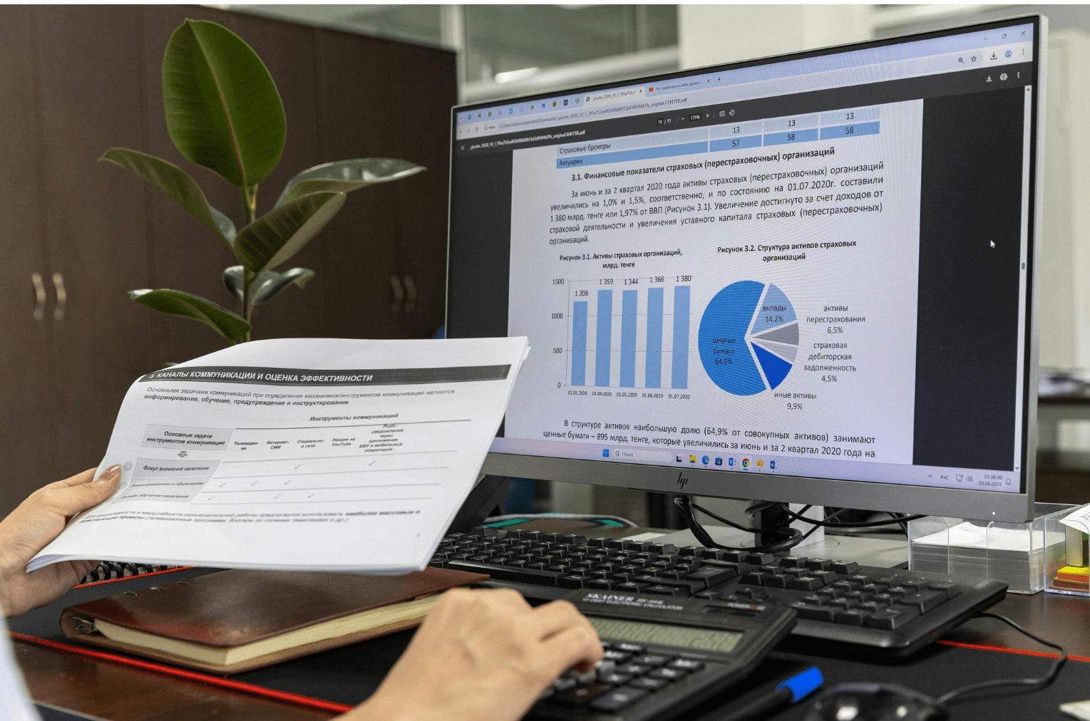 Profissional utilizando calculadora e analisando relatórios financeiros no computador sobre conformidade e multa LGPD empresa em escritório corporativo.