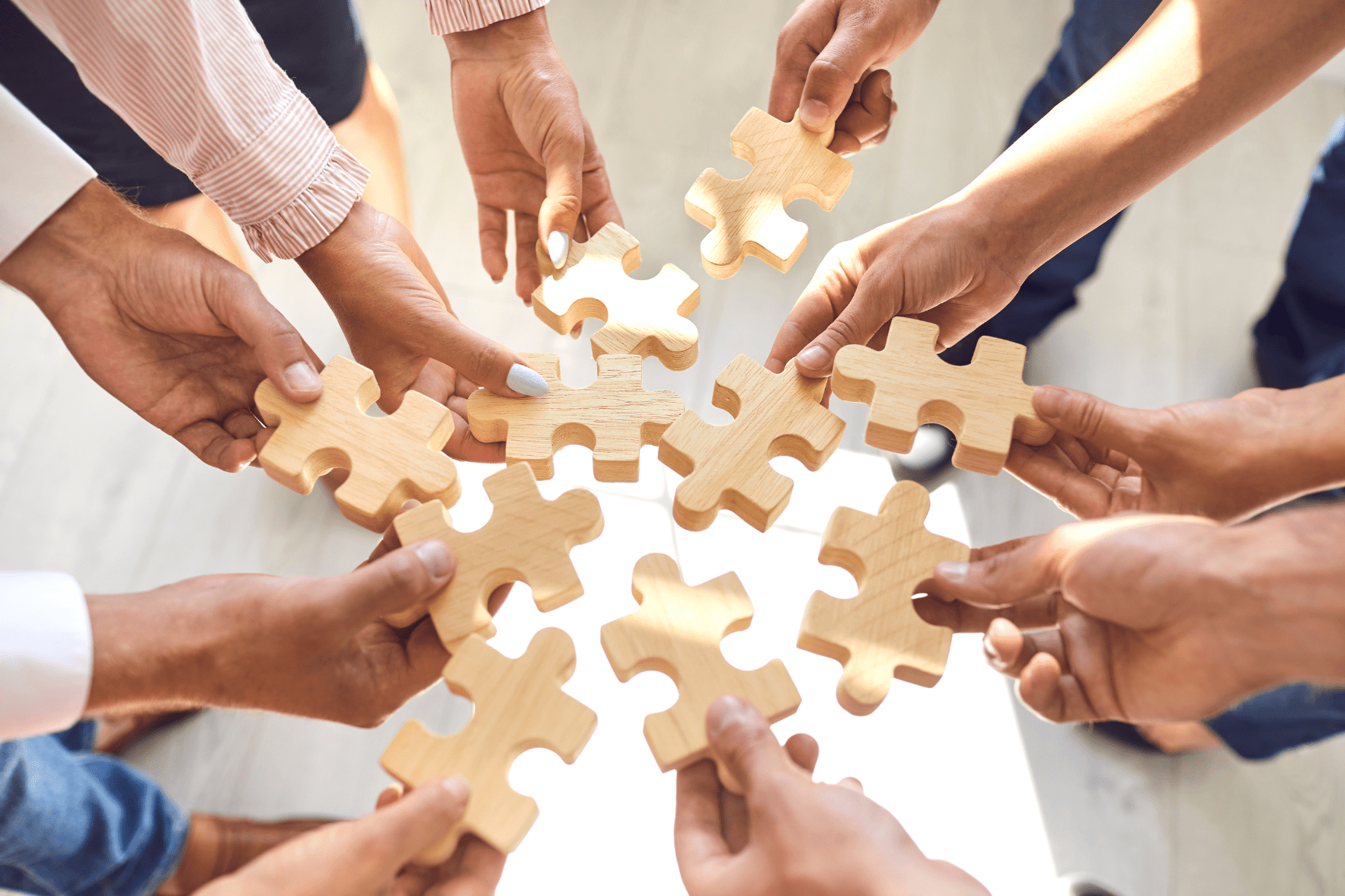 Equipe unindo peças de quebra-cabeça em uma dinâmica colaborativa que representa a construção de uma cultura ética baseada em código de conduta política anti-assédio canal de denúncias CIPAA, promovendo respeito, inclusão e cooperação no ambiente de trabalho.